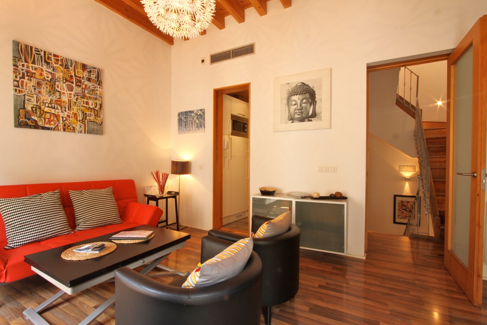 Salón con sofá rojo y vigas de madera — Dúplex Gomérez Granada